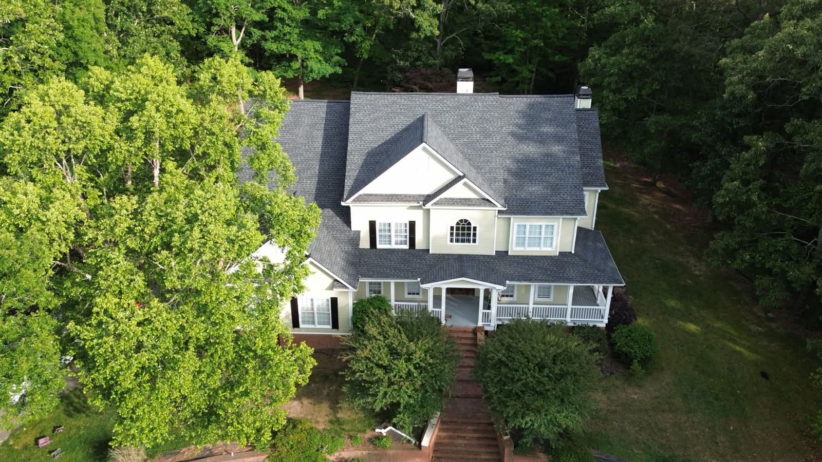 Completed dark architectural shingle roof on a two-story Georgia home